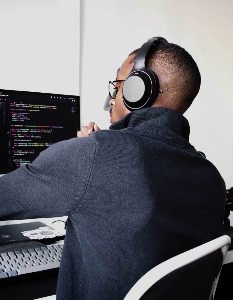 Un ingénieur portant un casque, assis à son bureau et travaillant sur un projet d'automatisation des tests.