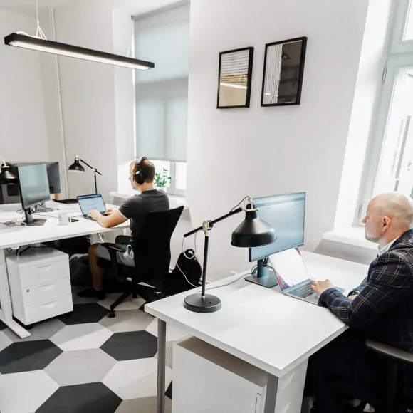Bureau en espace ouvert avec deux ingénieurs QA assis à leur bureau.