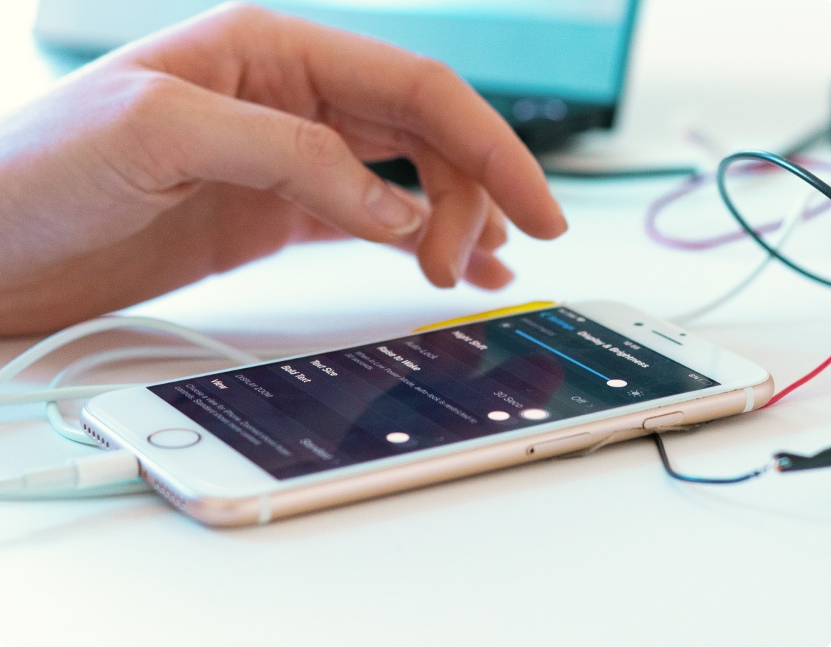 Un ingénieur AQ configure un appareil mobile pour des activités de test ultérieures.